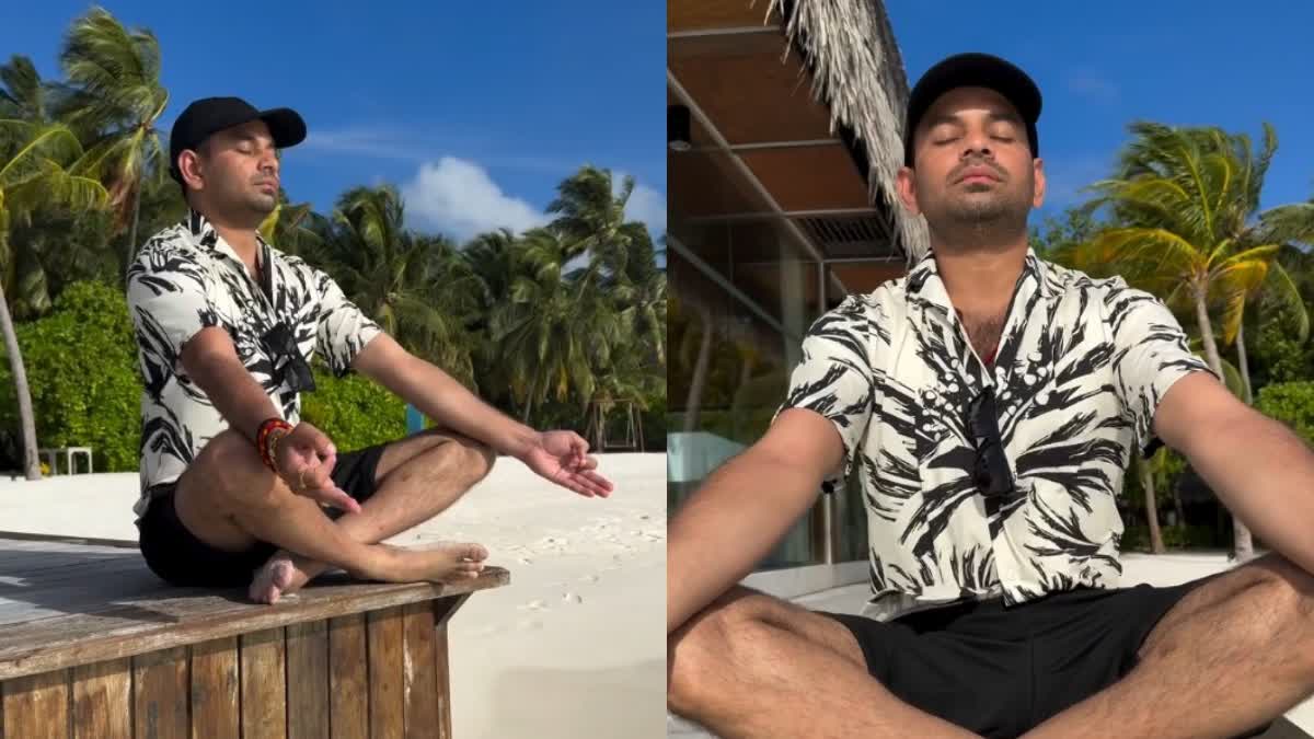 Tej Pratap Yadav meditating in Maldives wearing black shorts and black print on white half-sleeve t-shirt